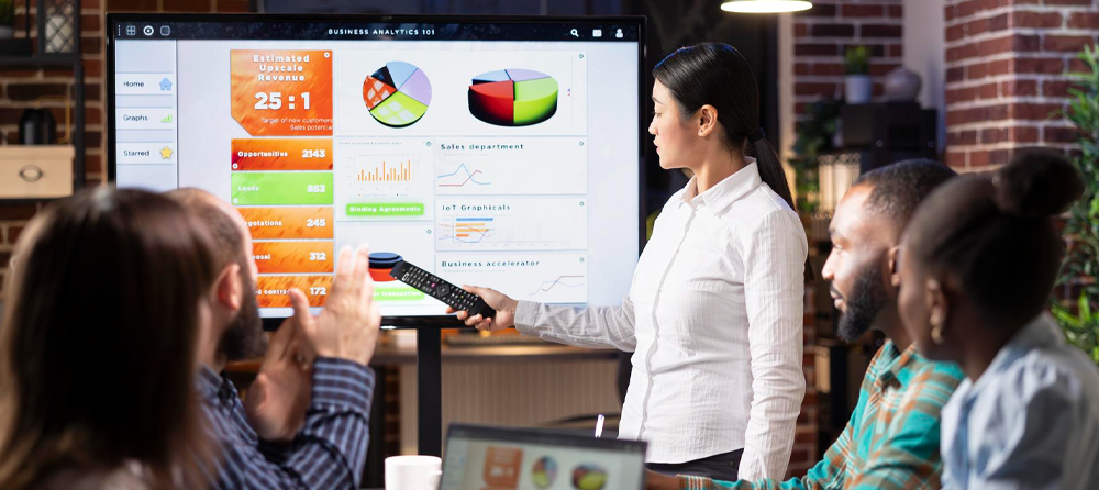 Imagem de uma reunião de colaboradores analisando gráficos em uma tela