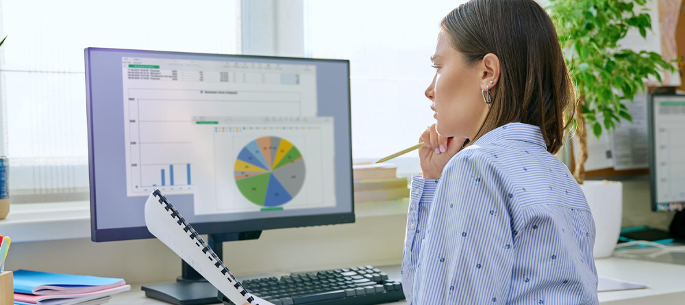 Imagem de uma colaboradora analisando gráficos em uma tela de computador