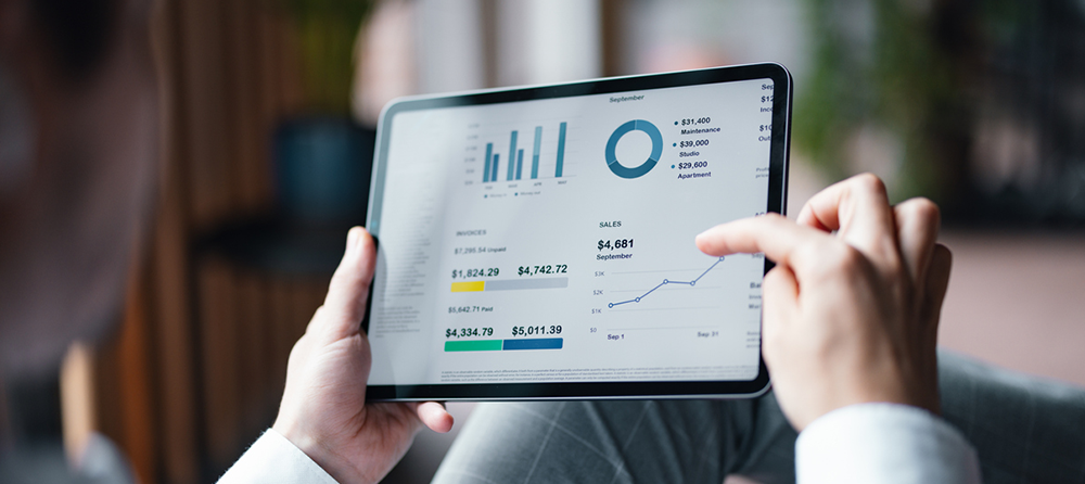 Imagem de uma pessoa analisando gráficos em um tablet