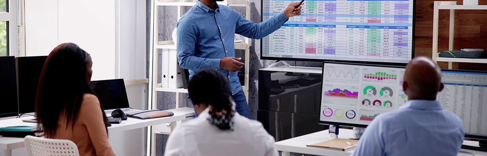 Executivos em reunião analisando indicadores