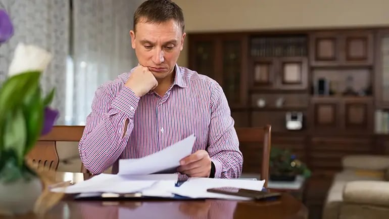 AN IMAGE OF A PERSON SEATED AT A TABLE LOOKING AT THEIR SALES TAX LICENSE. 