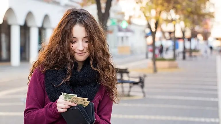 A WOMAN IN A PARK TAKING A LOOK AT HER INCOME EARNED.