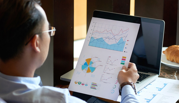 Uma pessoa analisando gráficos impressos 