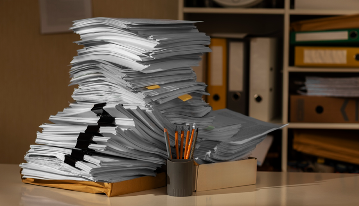 Imagem de uma pilha de documentos em uma mesa de escritório 