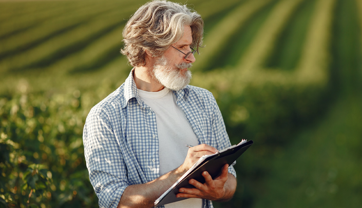 Imagem de um agricultor utilizando um tablet na lavoura