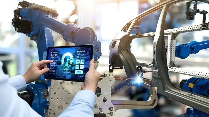 Mano de un ingeniero industrial sosteniendo una tablet