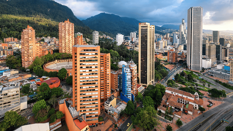 Downtown in the Santa Fe district, with the Santamaría Bullring, modern skyscrapers, and the Monserrate Sanctuary in daylight, Bogotá.