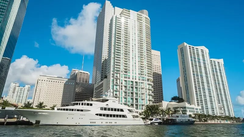 Boat moored in the port of Miami with white skyscrapers behind.