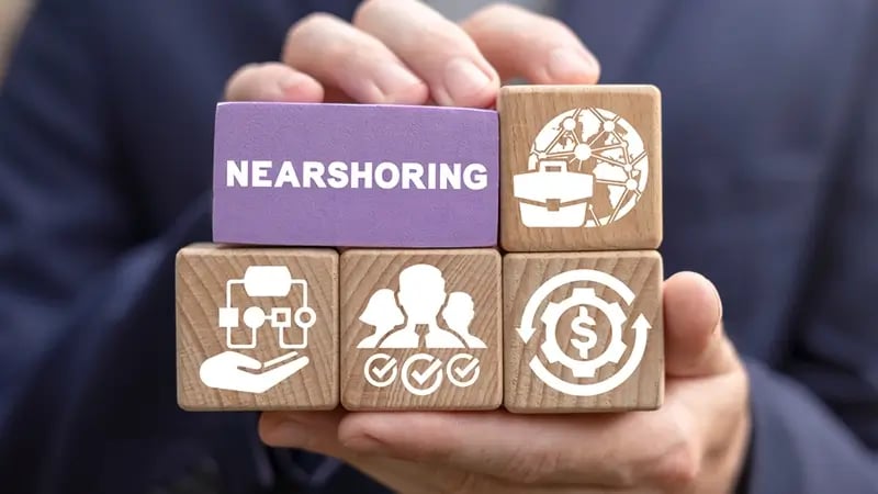 concepto de nearshoring eb loques de madera sostenido entre dos manos.