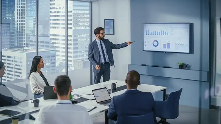 A GROUP OF PEOPLE IN A CONFERENCE ROOM DISCUSSING STRATEGIES TO REDUCE SHORT-TERM CAPITAL GAINS TAX.