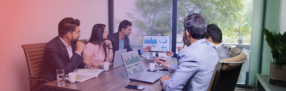 Imagem de pessoas em uma sala de reuniões observando gráficos