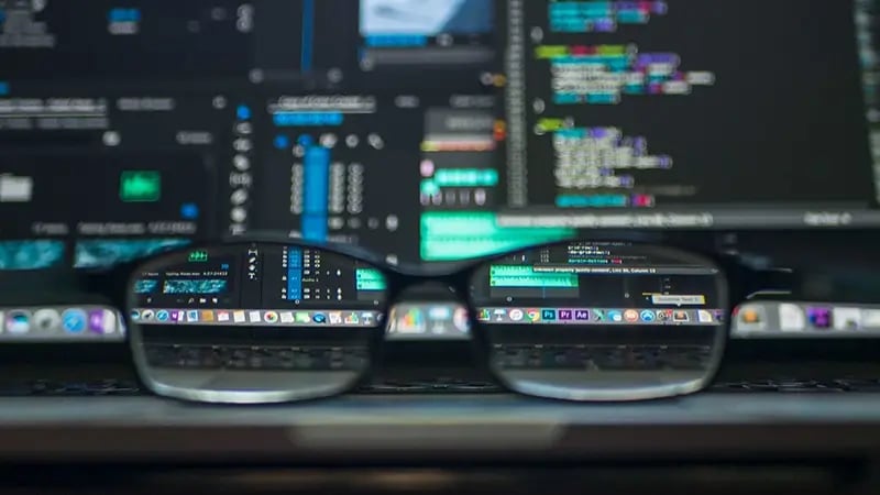 Óculos sobrepostos na frente de um monitor com uma tela ilustrando Big Data