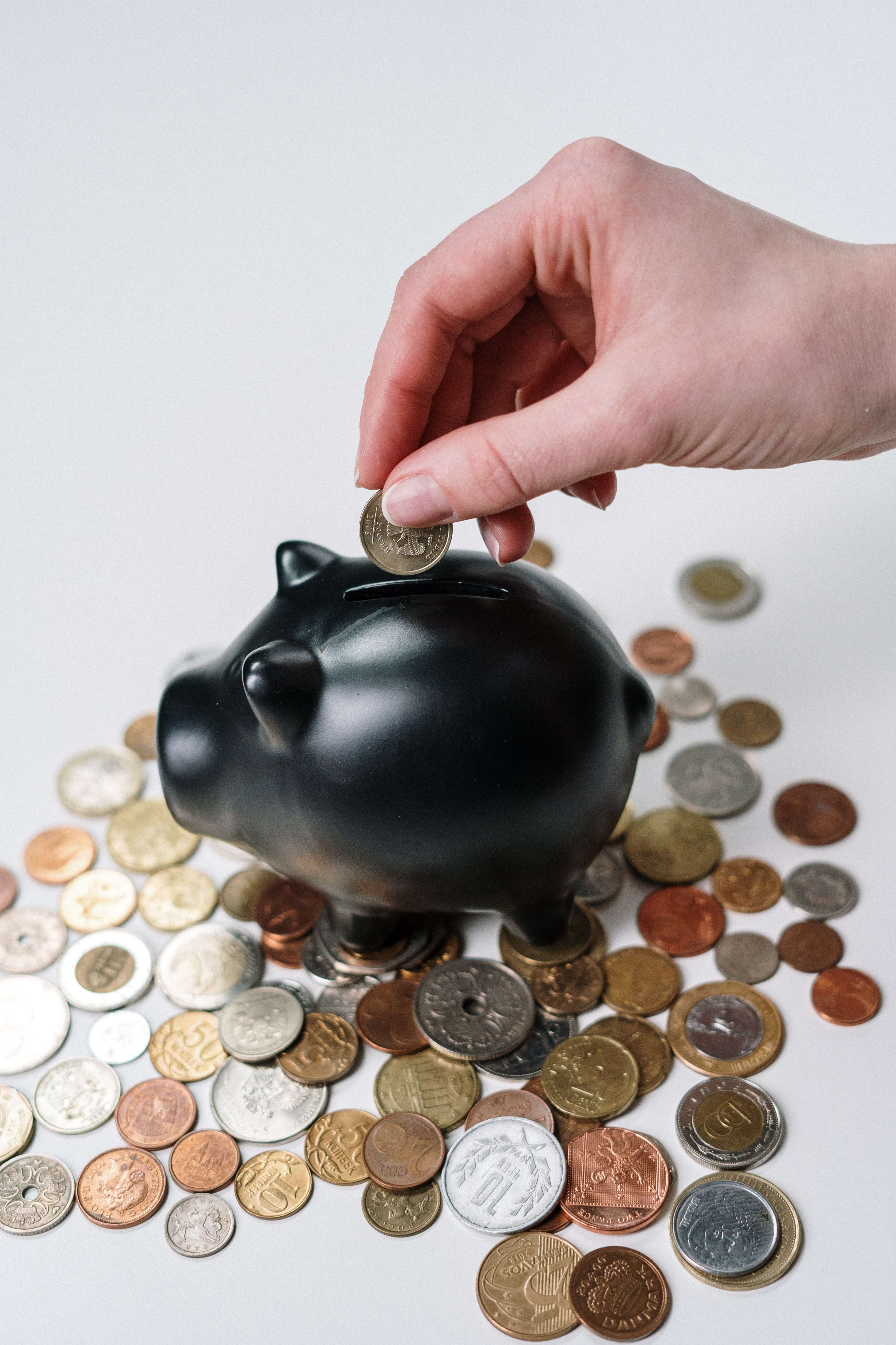 Black piggy bank with coins around