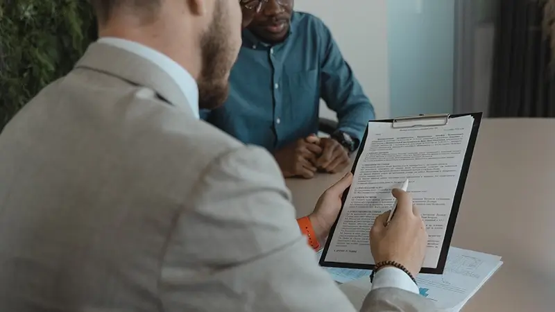 RECRUITER REVIEWING CANDIDATE'S RESUME AT THE JOB INTERVIEW